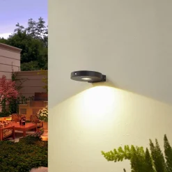 Lucande LED wandlamp Tavon, rond, zwart, sensor